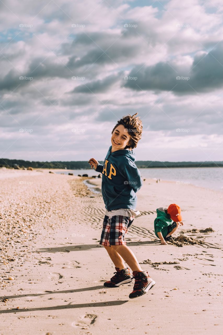 Young boy laughing playing on the beach