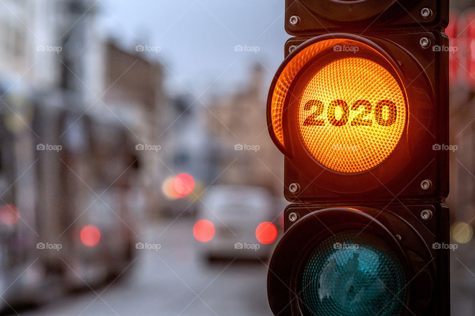 A city crossing with a semaphore. Orange light with text 2020 in semaphore. Symbolic New Year approaching concept