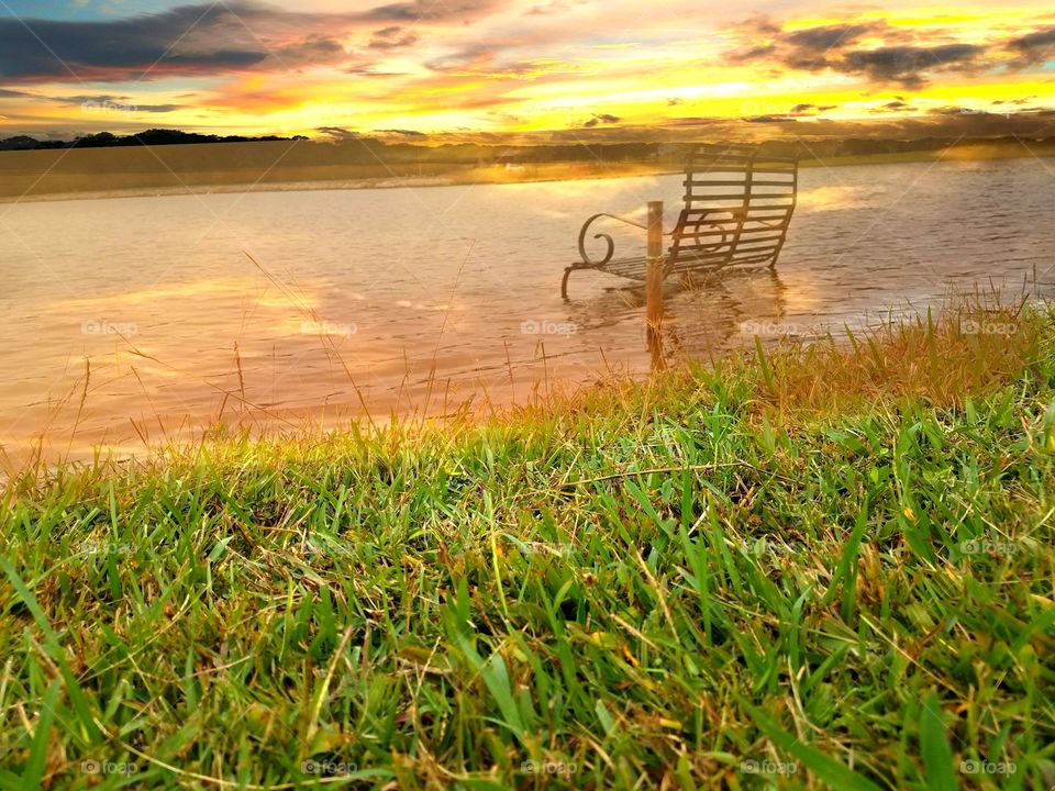Bench in the water in the sunset