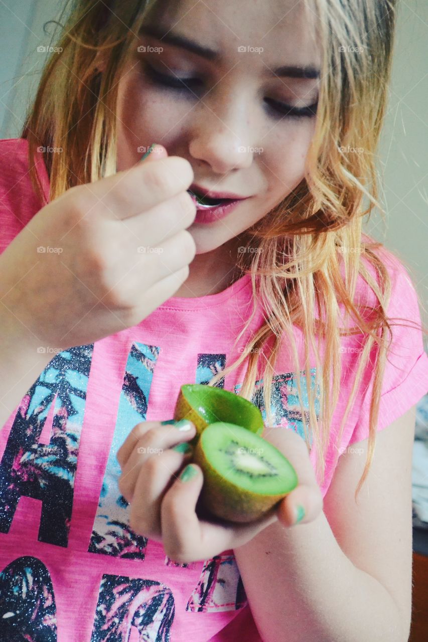 Girl eating kiwi