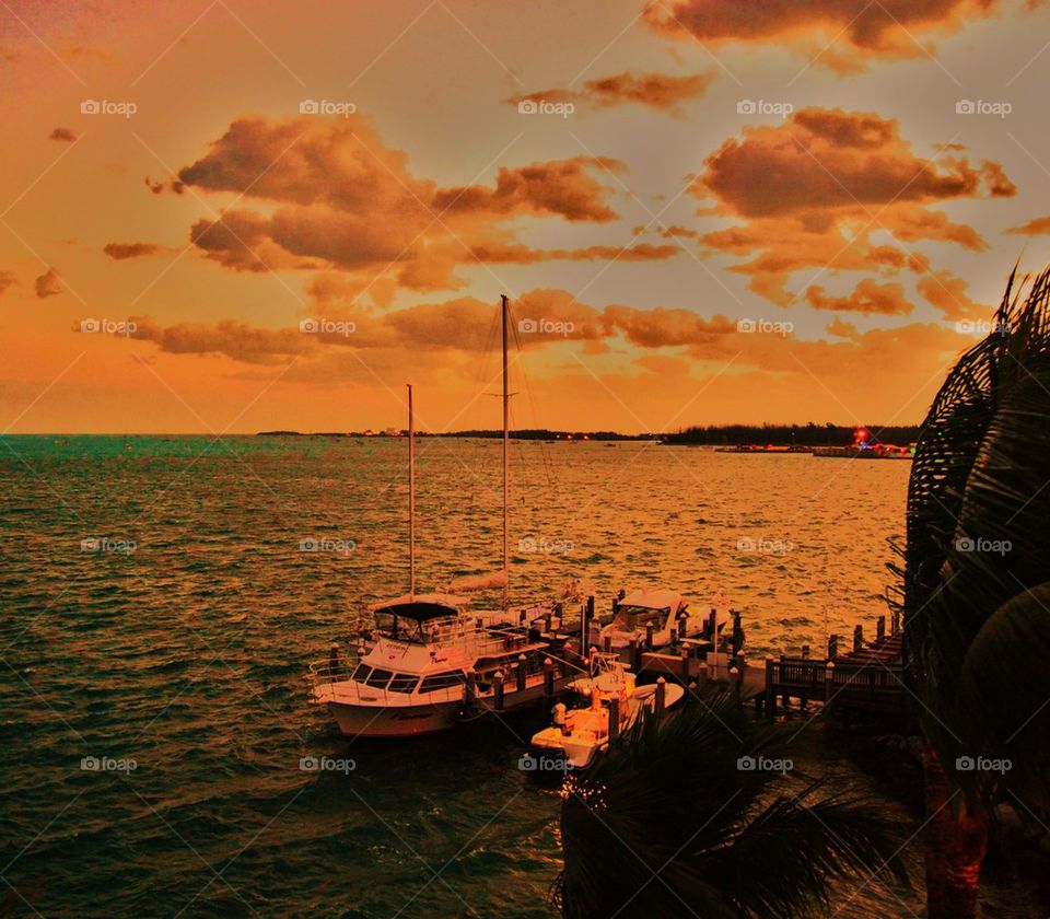 Boats on water at sunset