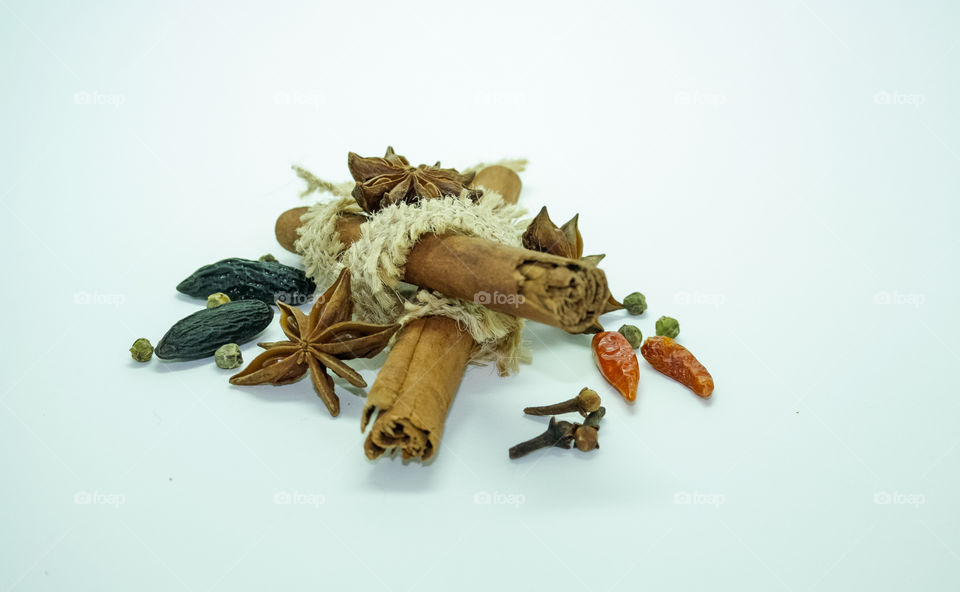 spices, cinnamon bar, cloves, anise, tonka, chili peppers, with an old burlap cloth, spices on a white background