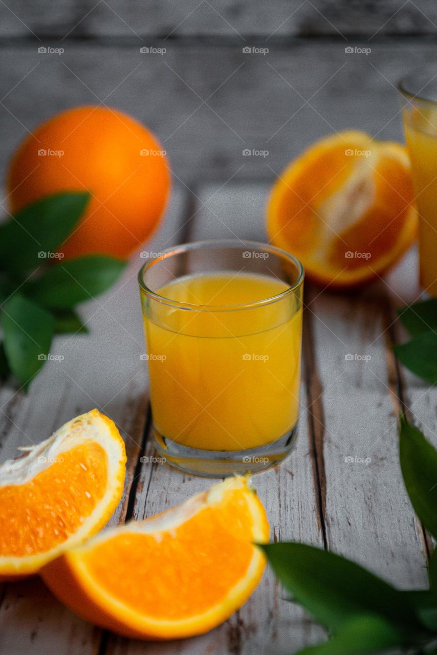 Food still life in rustic style freshly squeezed orange juice in a glass and on a blue wooden background