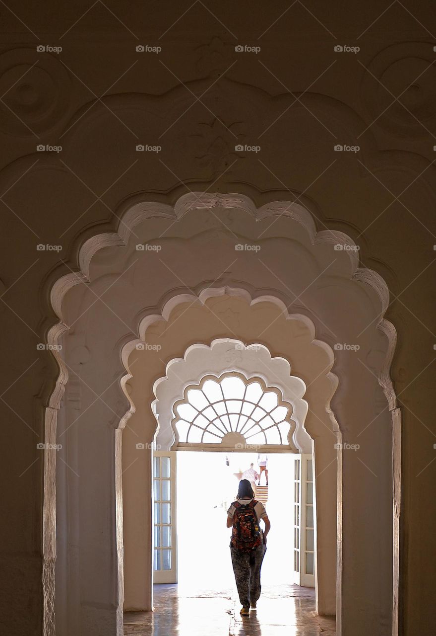 a tourist walking between the arches