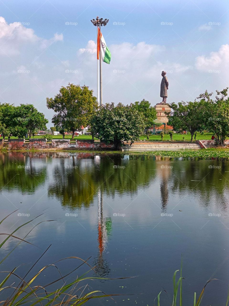 reflection of statue and indian flag onto the water.