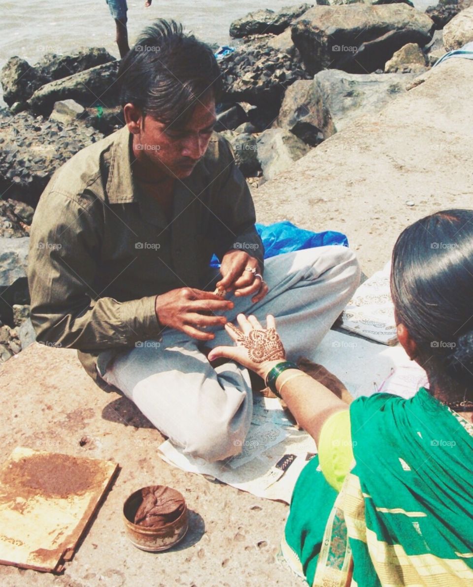 Women having henna tattoo painted on her hand 