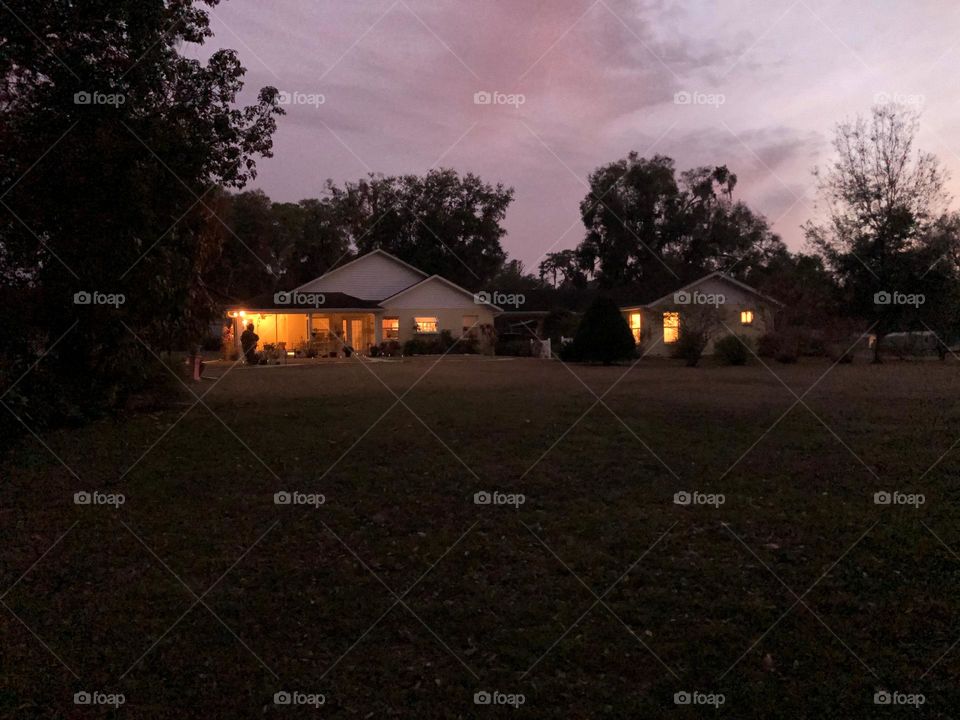 Country duplex house with lighted windows at dusk