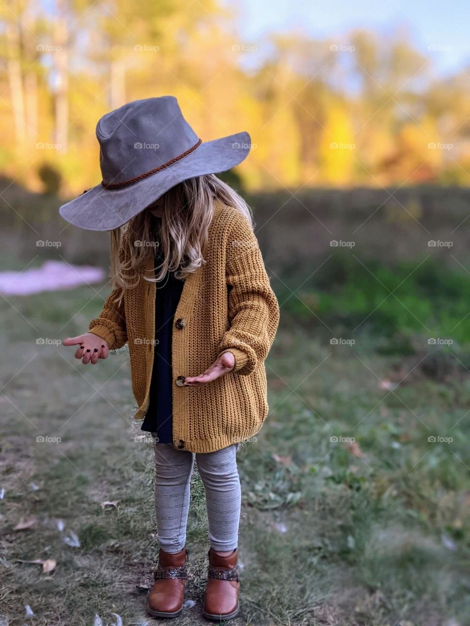 oversized fall suede hat and mustard sweater on girl with fall colored leaves on trees in the background at the park, fall in the park, state parks in fall