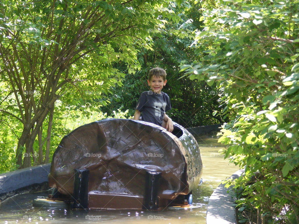 Boy riding the log/water ride at the zoo