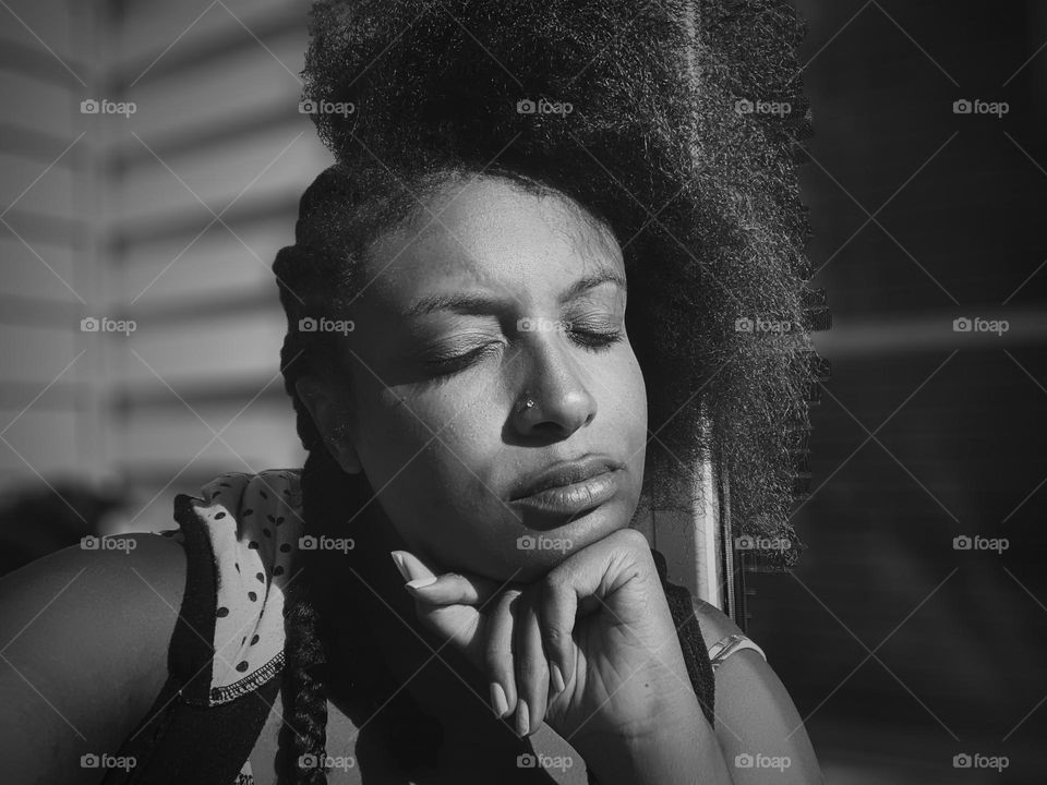 Black woman taking out her protective style cornrows