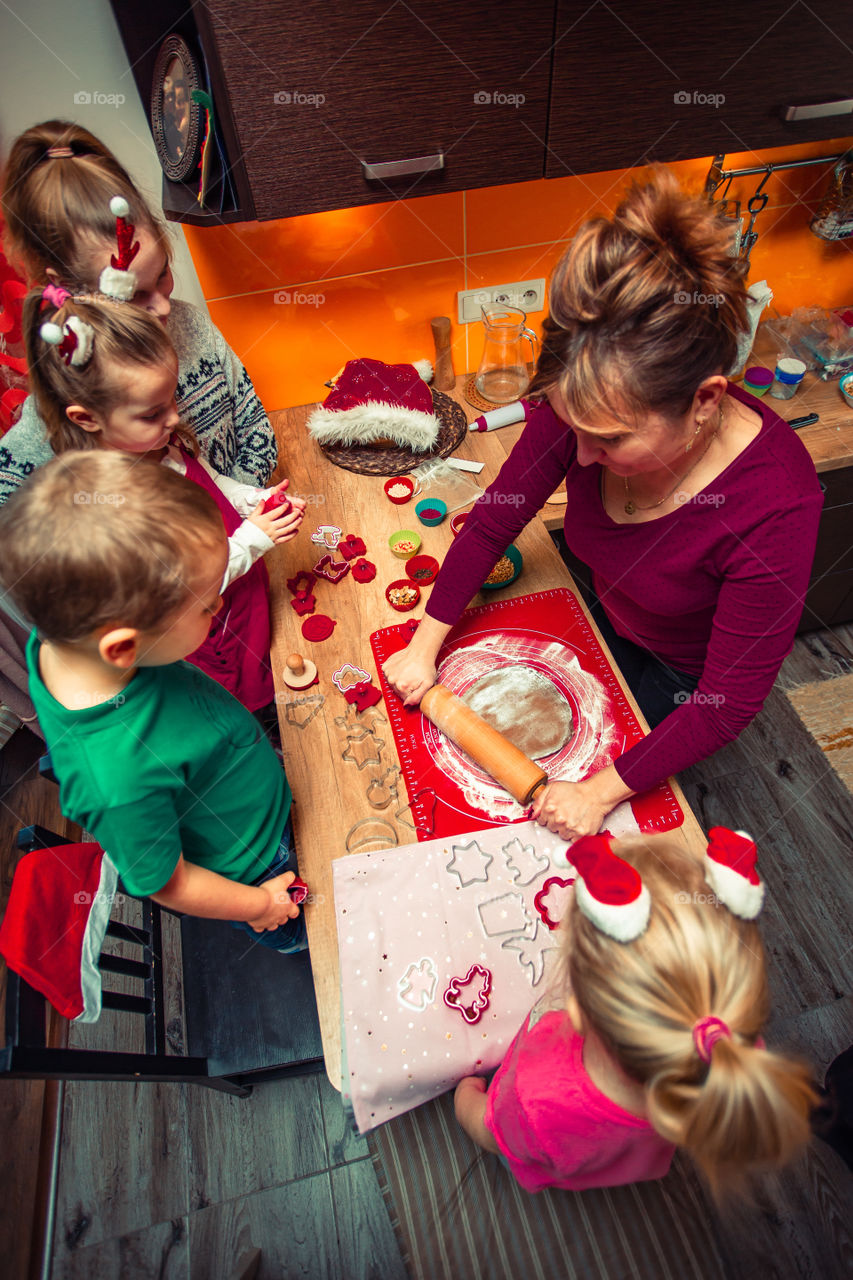 Baking Christmas cookies. Christmas gingerbread cookies in many shapes decorated with colorful frosting, sprinkle, icing, chocolate coating, toppers, put on table. Baking traditional cookies. Family celebrating Christmas. Baking at home