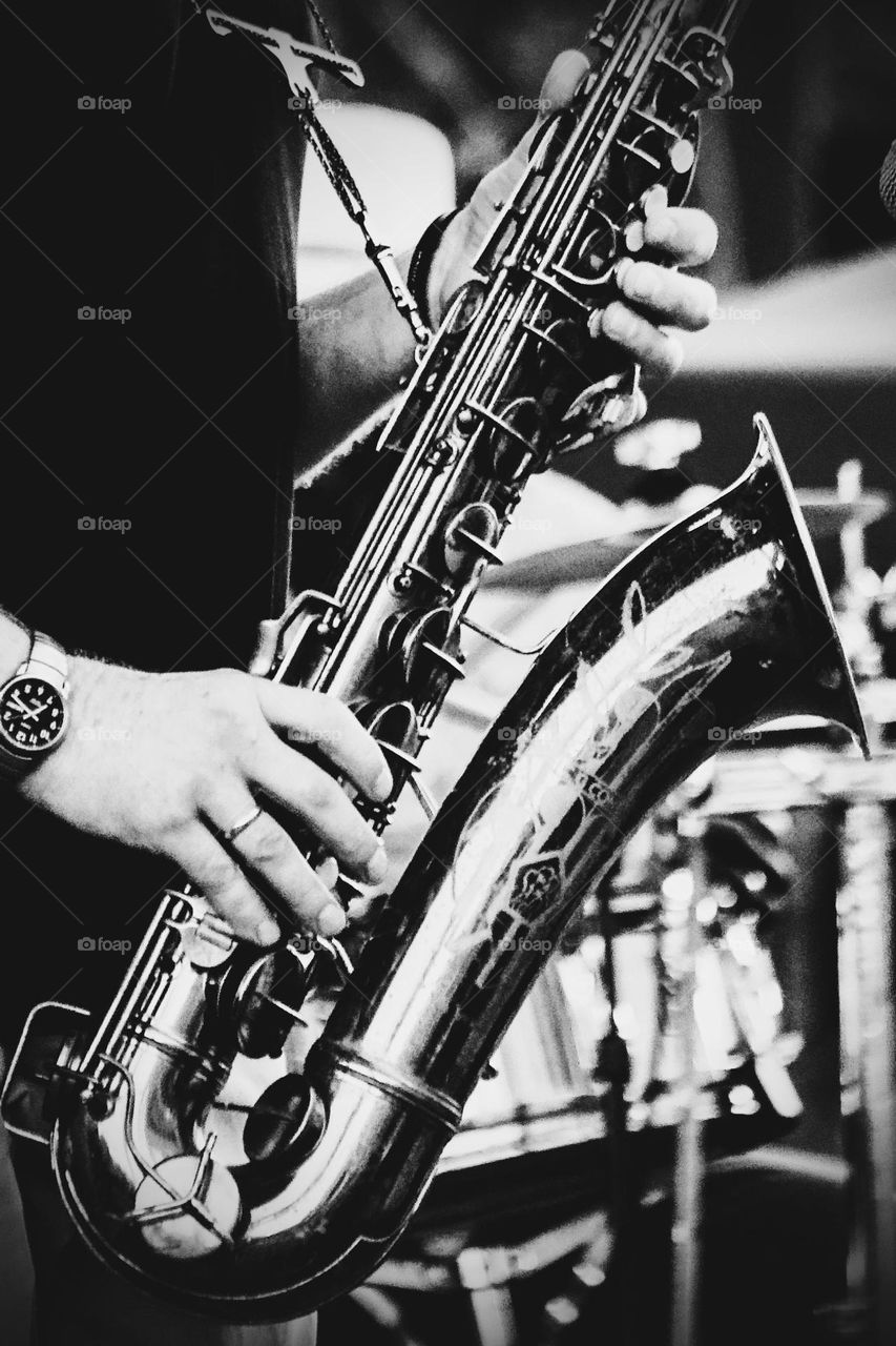 A man playing a saxophone. The saxophone is a part of the woodwind instrument.