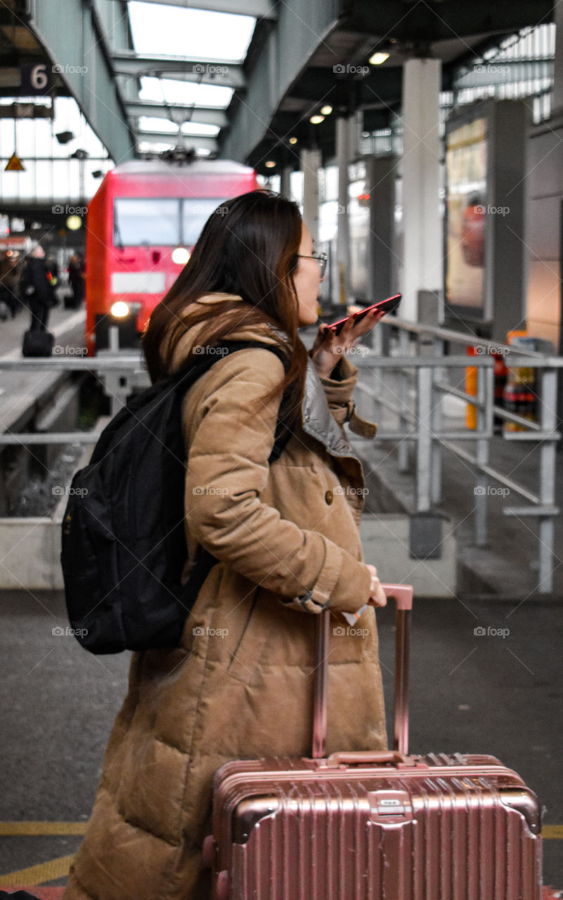 women with suitcase and mobilphone at the station