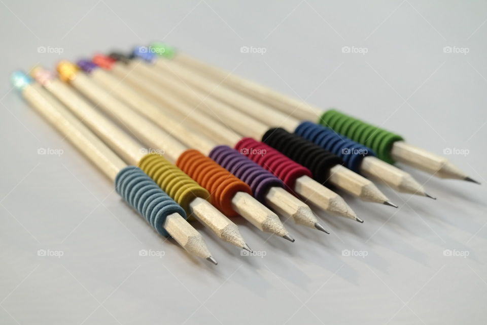 Pencils colorful erasers in white paper sheet 