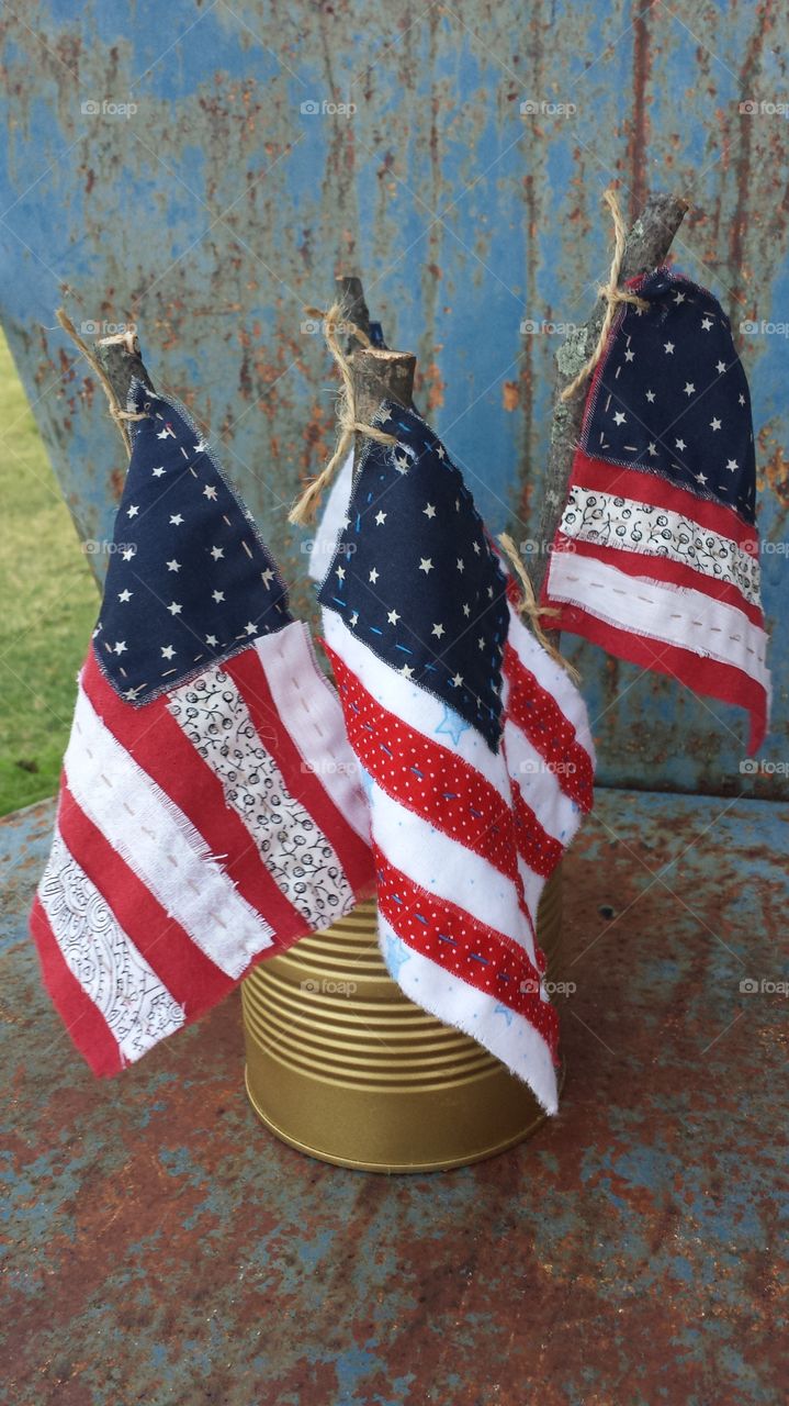 Handmade rustic quilted patriotic American flags displayed on vintage chair.