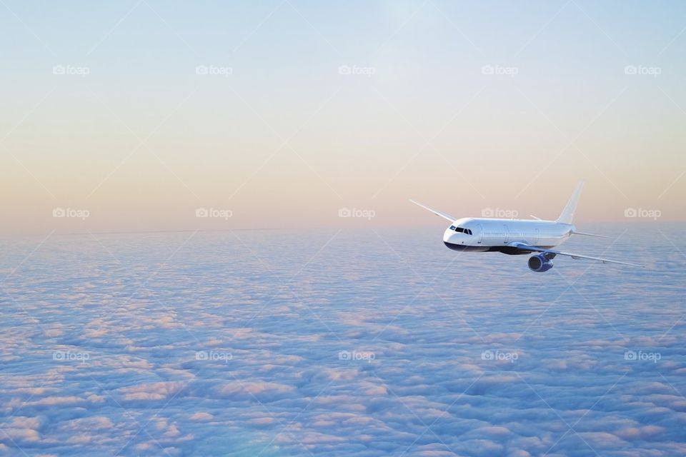 Aero plane flying above cloud at sunset