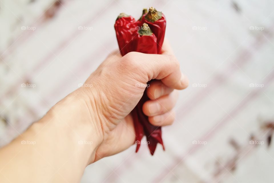 Person's hand holding red chili