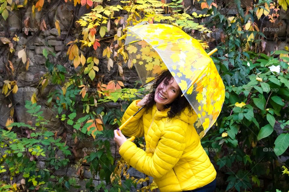 Smiling Woman with Umbrella on Autumn Background