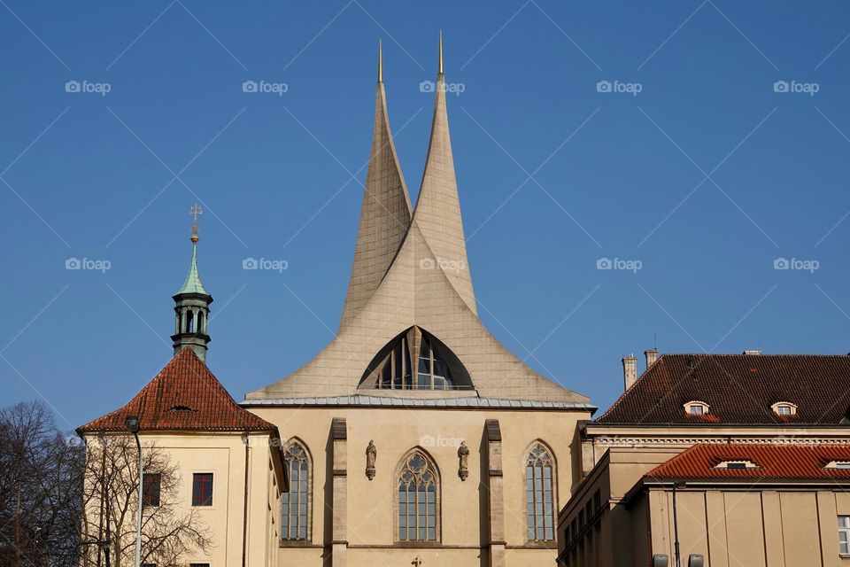 Benedictine monastery Emauzy, frontal view. Architectural monument from fourteen century with two modern spiky towers on sunny day in Prague