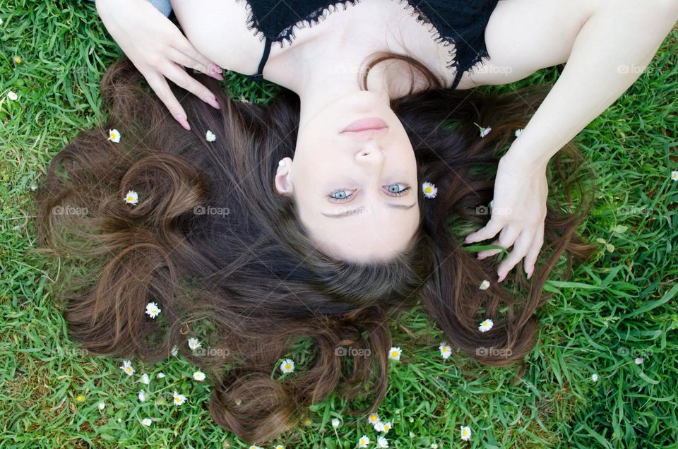 Portrait of Beautiful Young Girl on Background of Daisies