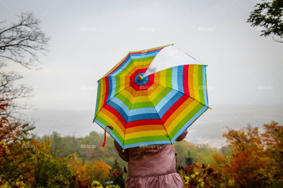 Child is holding a colorful umbrella