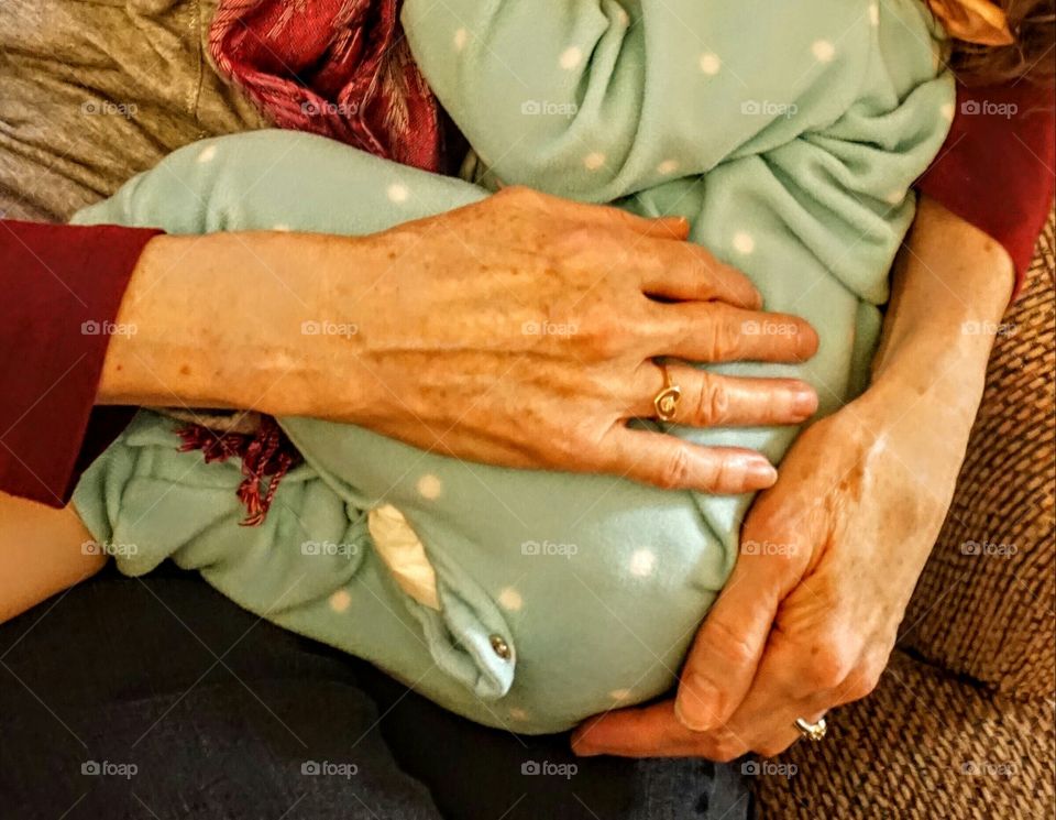 67 year old grandma holding her first grandchild in her arms during an ear infection.