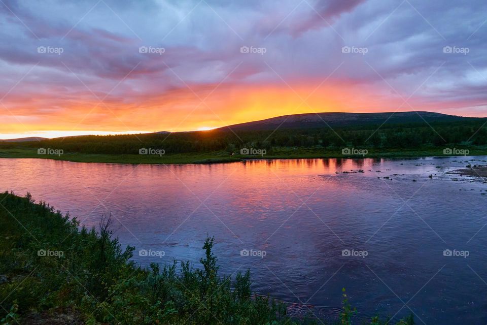 Upper part of the Lainio river and mountain at sunset time in 2022 which is located in wilderness of Kiruna municipality in far north of the the Swedish Lapland.