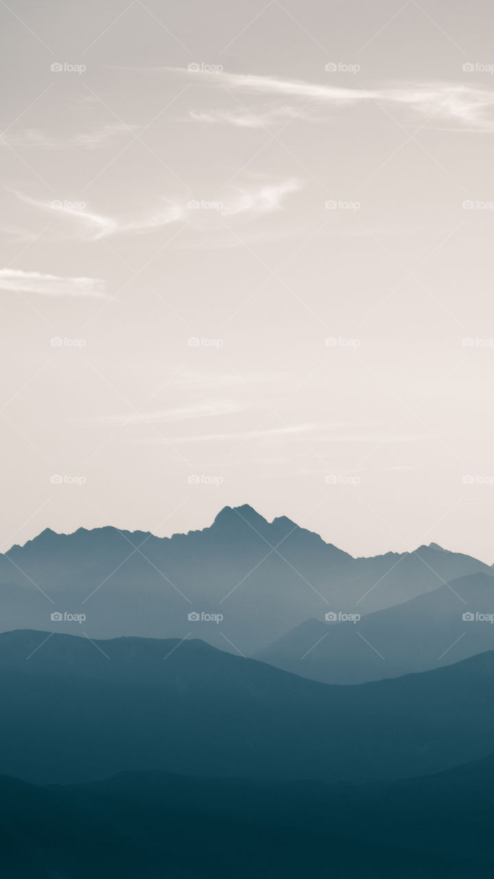 An inspiring mountain landscape. Tatry mountains in Slovakia. A beautiful wallpaper for smartphone screen. Monochrome blue abstract gradient with perspective.