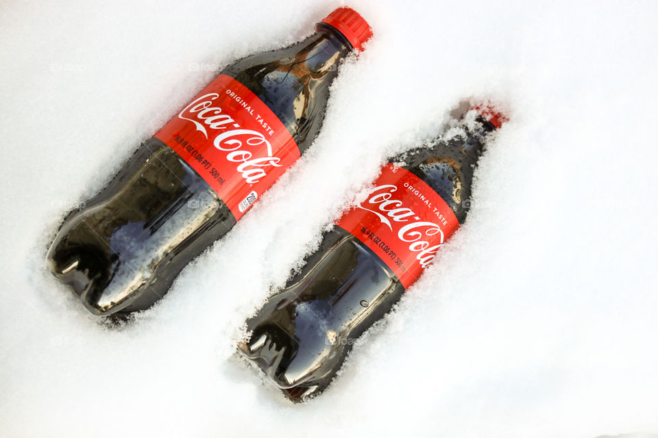 CocaCola- two bottle in the snow.