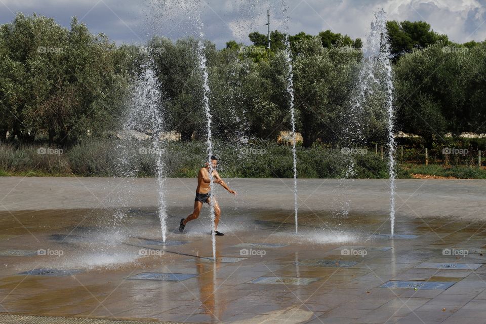 boy playing with water jets