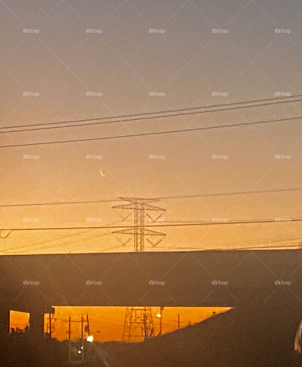 Cold Blustery evening and Night Winds Howling after Late Season Cold Snap. Now this morning a Hazy Cold Morning Beautiful Sunrise and a Sliver of the Moon in Center Position.