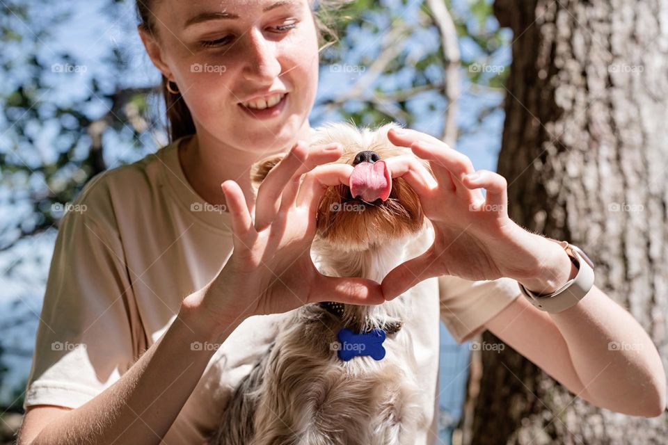 woman and her dog, making heart gesture with hands, pet care