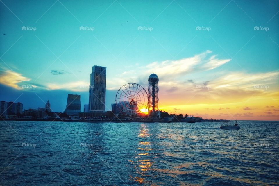 Panorama of Illuminated Resort city Batumi. Bright Evening Sky. View From Sea Beach To Illuminated Cityscape