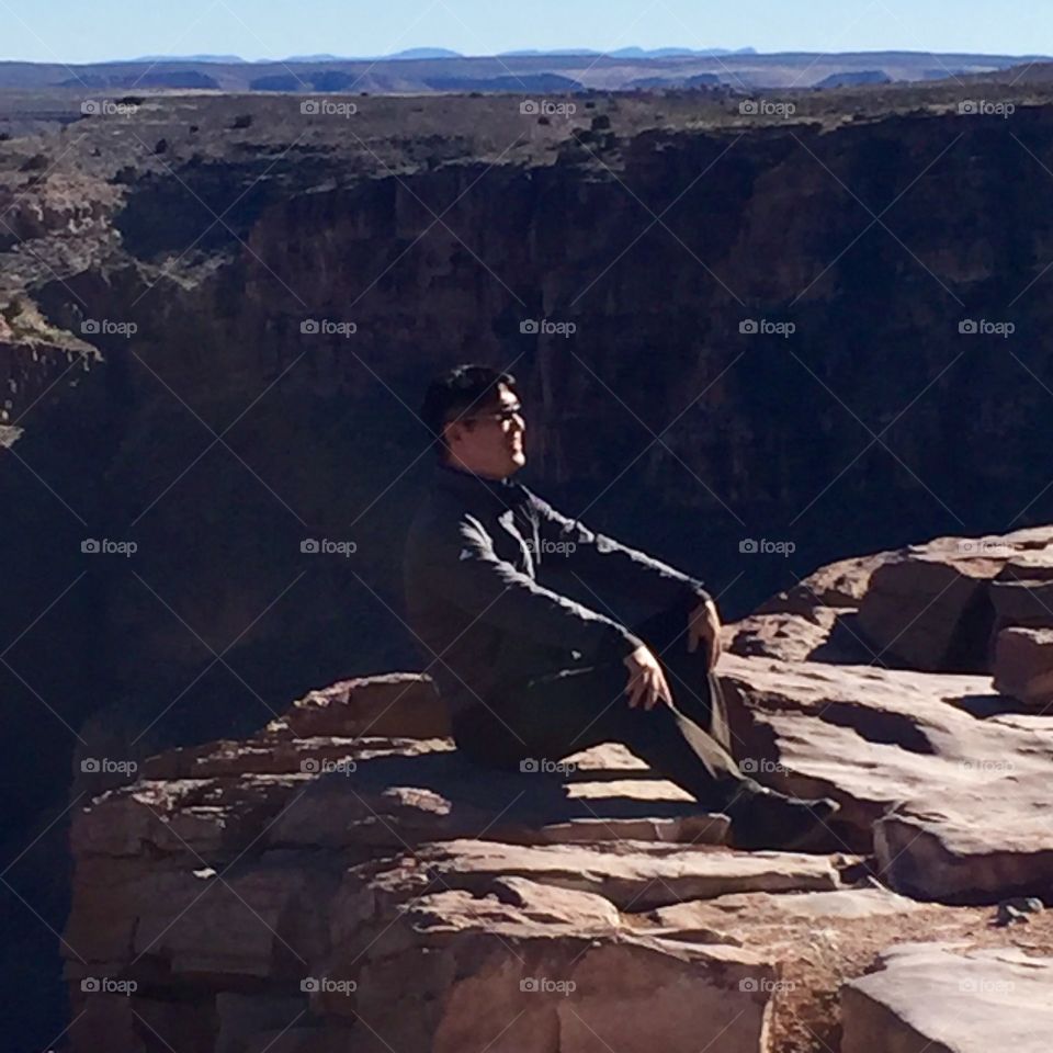 Cool guy sitting on the edge of the Grand Canyon