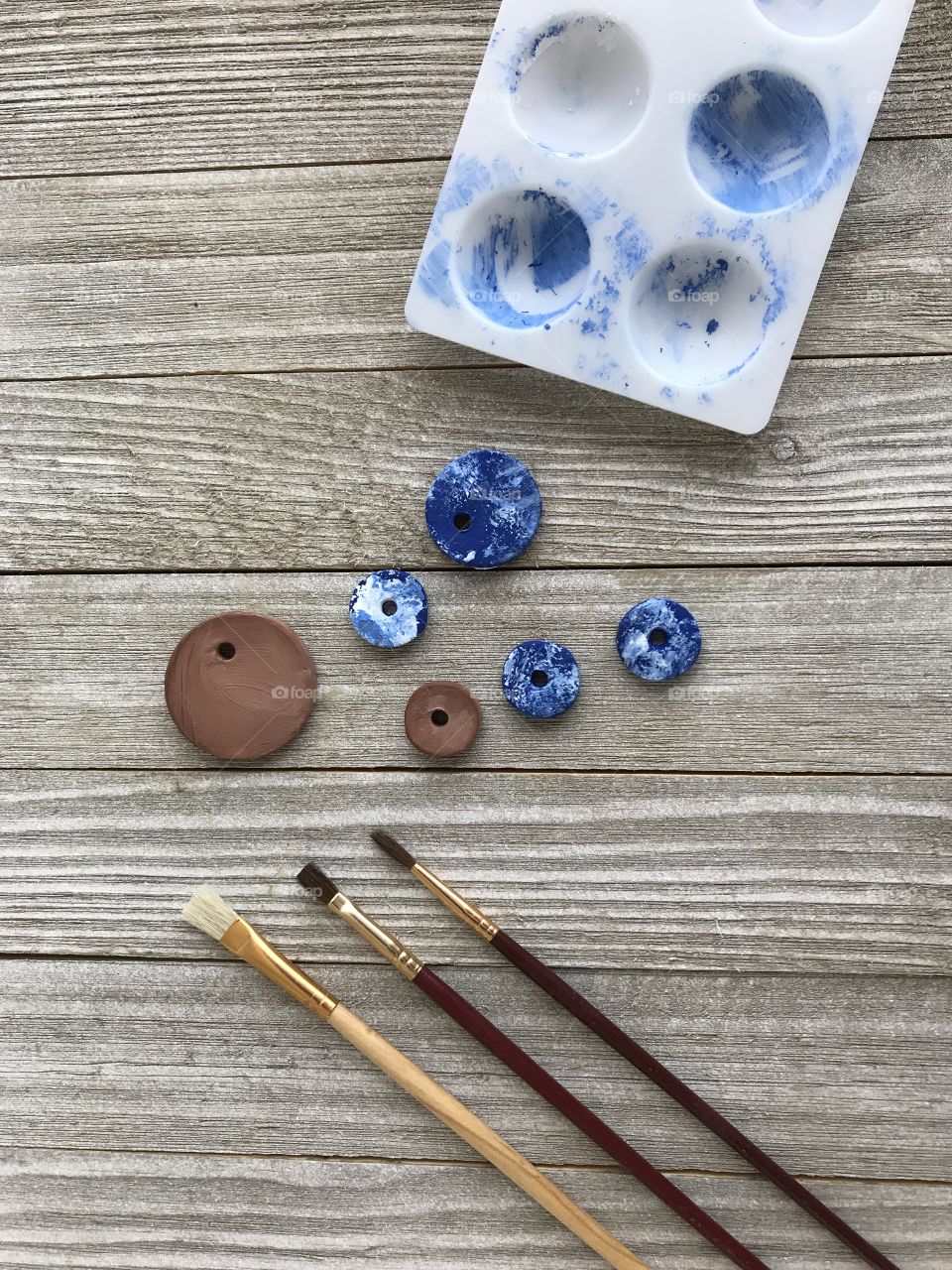 Painting various size of clay beads blue!
