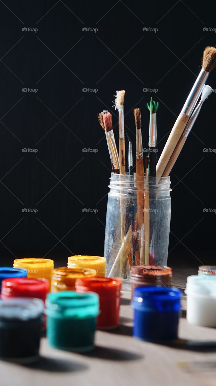 Paintbrushes and watercolor with black background