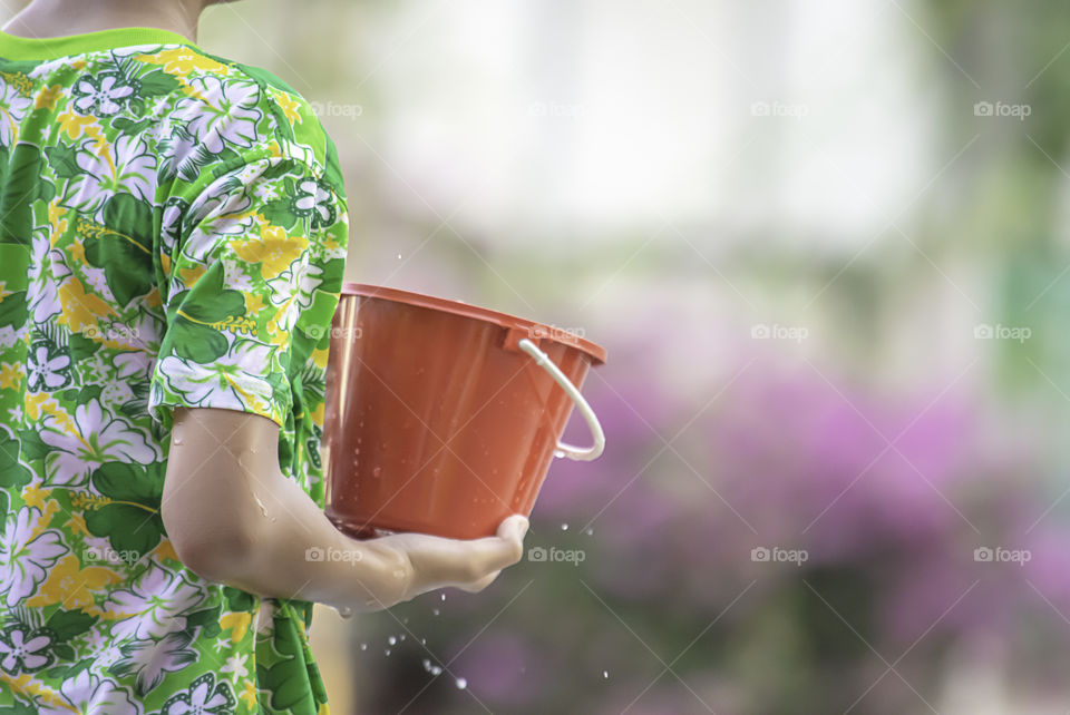 Hand holding Plastic bucket play Songkran festival or Thai new year in Thailand.