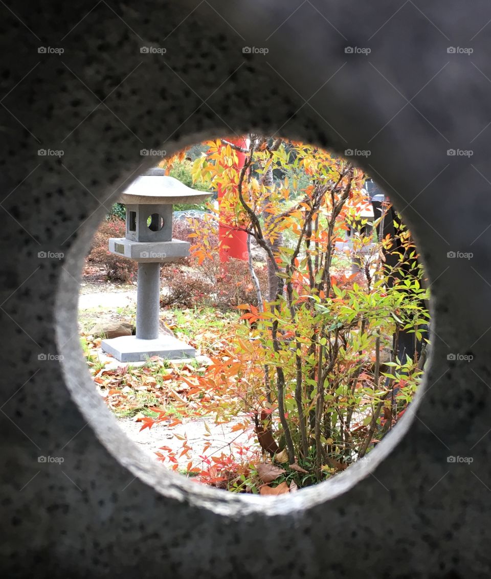 A keyhole glimpse into a beautifully-manicured Japanese garden at Lake Merritt in Oakland, California. 