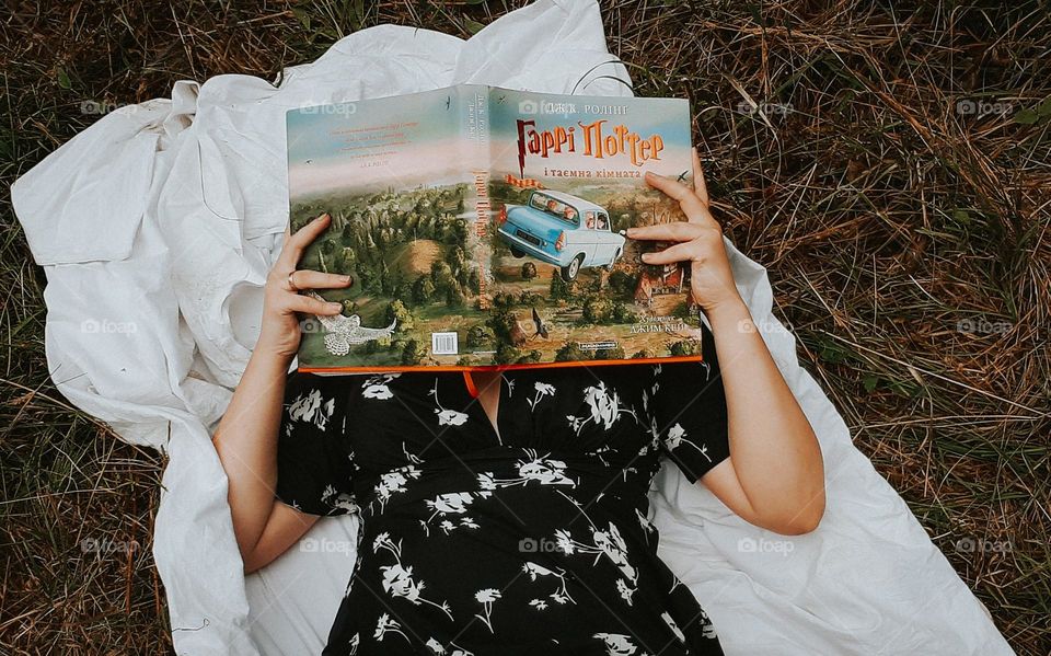 Reading a book on a white sheet in the middle of nature