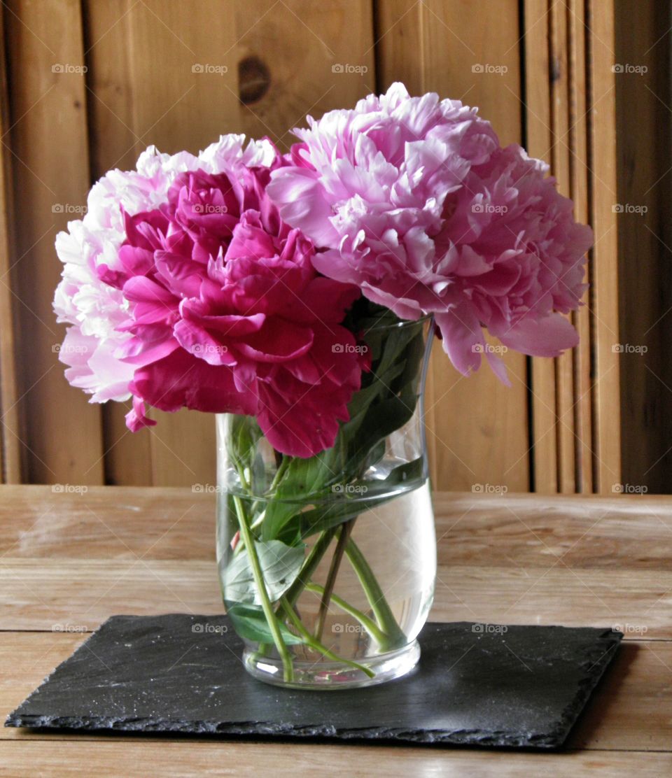 Bouquet de pivoines rose et blanche dans une décoration bois