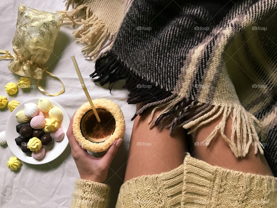 Drinking coffee with candies in cozy bed 