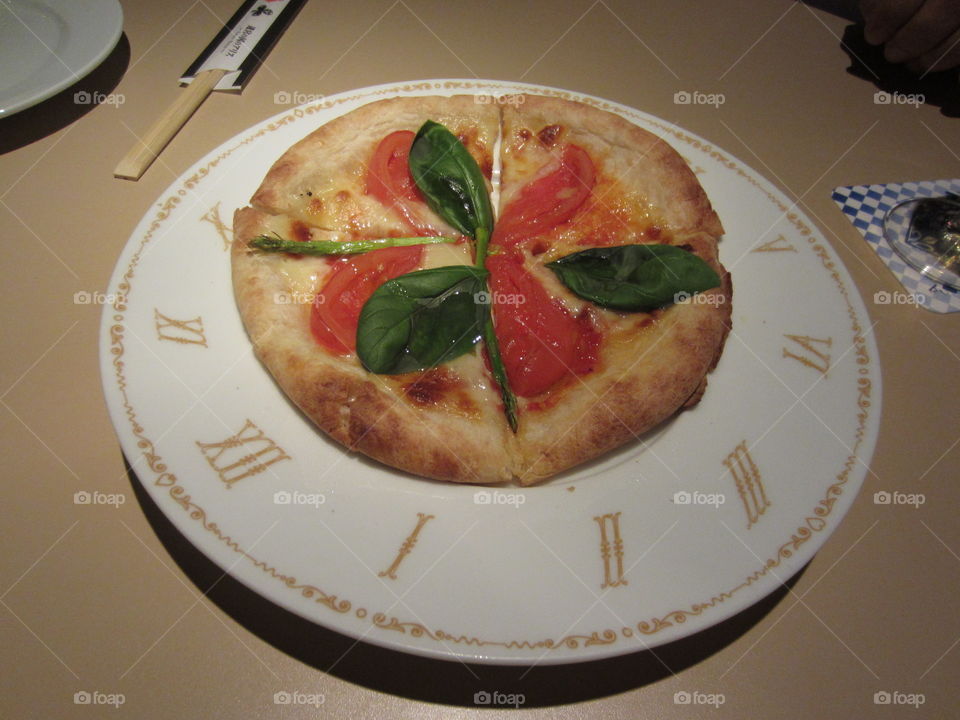 Clock Shaped Plate of Pizza with Basil Leaves