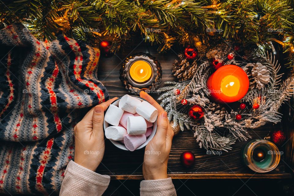 Xmas flat lay. Drinking hot cocoa with marshmallow,burning candles. Garland festive lights. Winter beverage. 