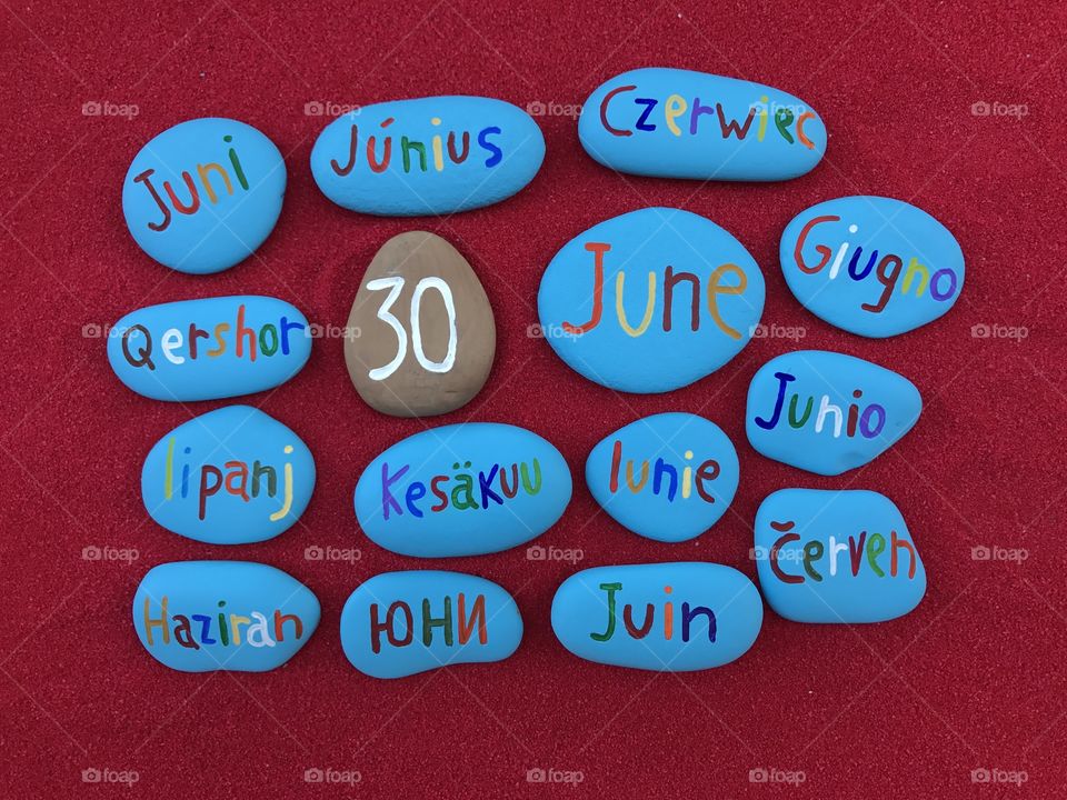 30 June, calendar date in many languages with colored stones and red background 