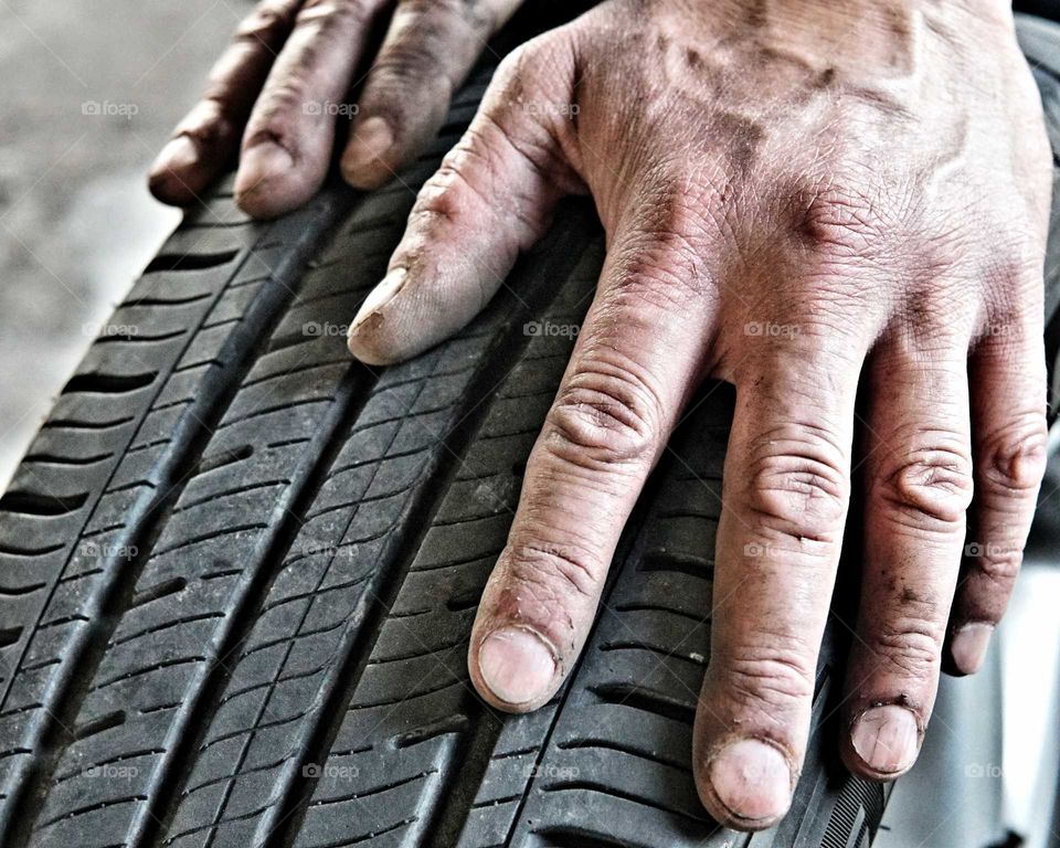 Close-up of man's hand and tyre