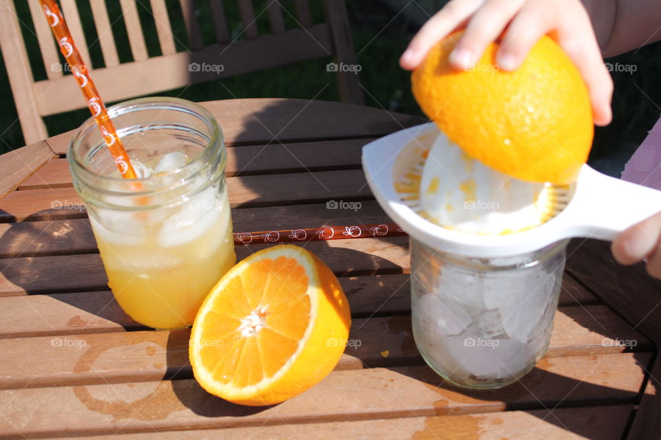 A person squeezing orange