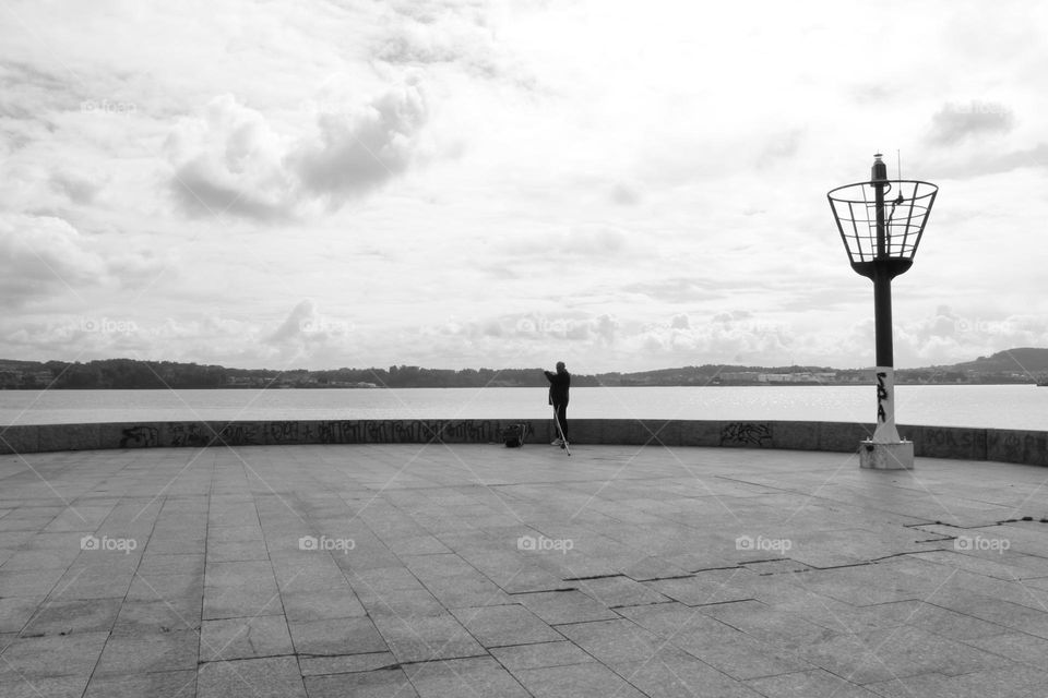 Lonely fisherman on the mole of Caranza, Ferrol.  Galicia, Spain.