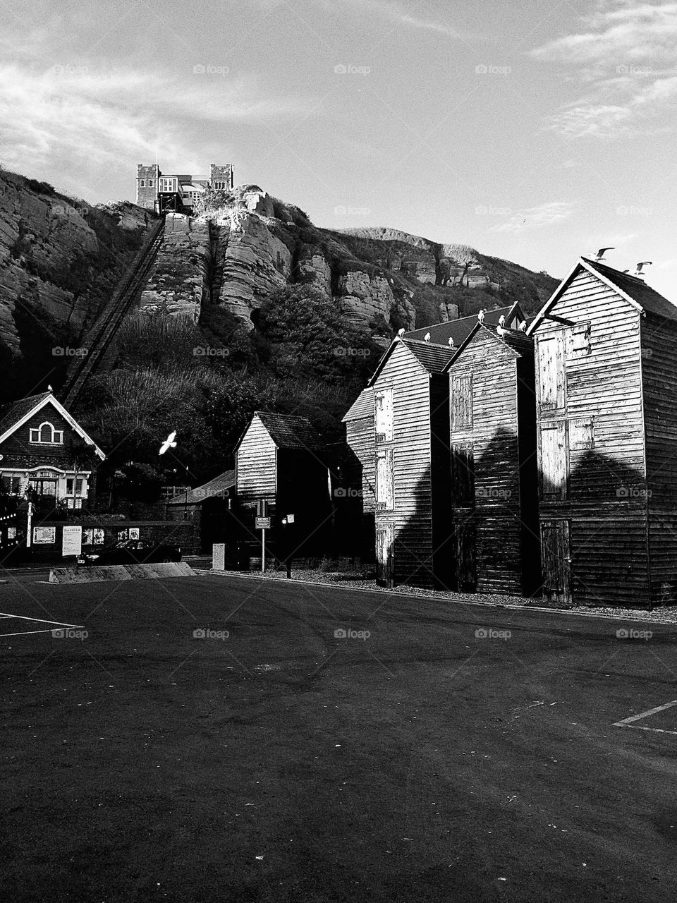 Dramatic black and white photograph of the fishing net huts and East hill funicular cliff railway in Hastings