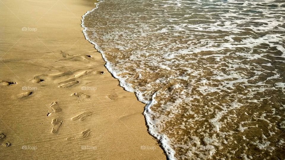 High angle view of waves on shore at beach