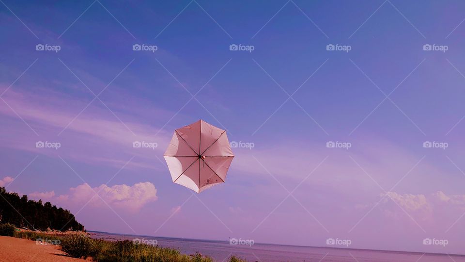 Sunset and flying umbrella on the Baltic sea